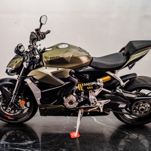 Green Ducati motorcycle parked indoors.